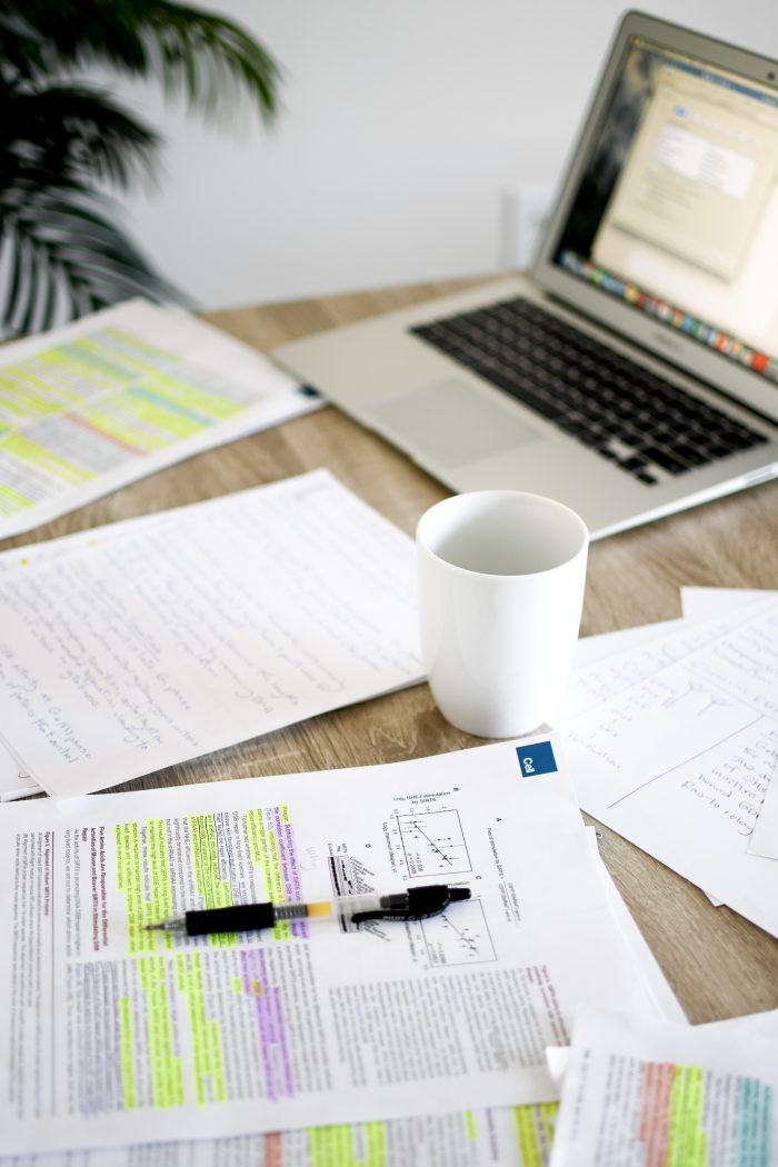 laptop and papers with a coffee