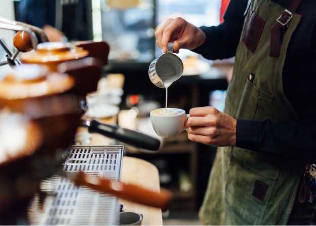 a barista making a coffee drink