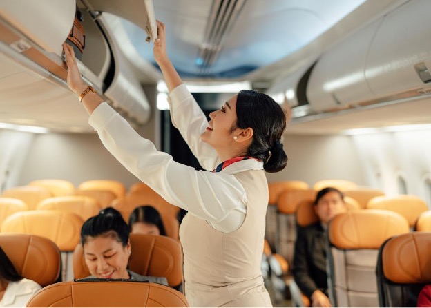flight attended putting a bag in the overhead.